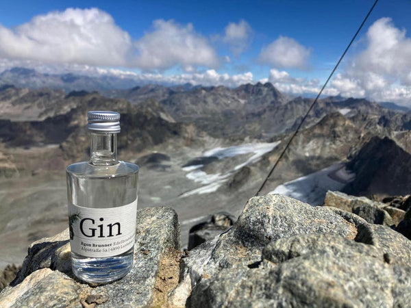 Gin in Miniflasche der Destillerie Brunner auf dem Piz Buin mit Ausblick auf die Silvretta im Montafon.