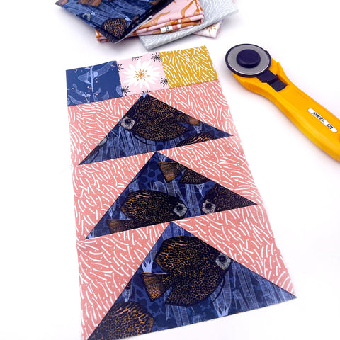 Flying geese quilt blocks with patchwork squares at the top