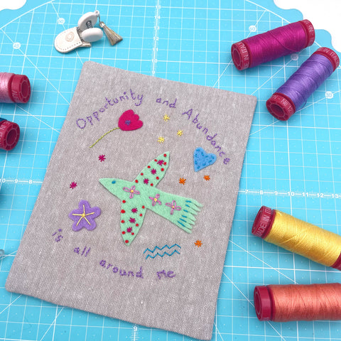 Positive affirmation embroidered with a bird and flowers in felt