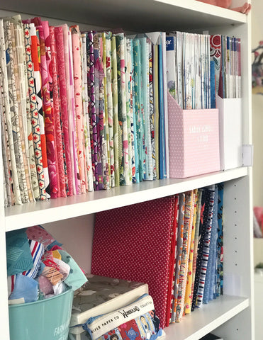 Fabrics on shelf, in colour order 