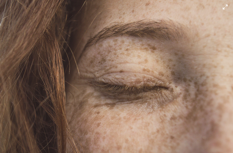 Zoomed in on a woman's eye which is shut. She has no eye makeup on.