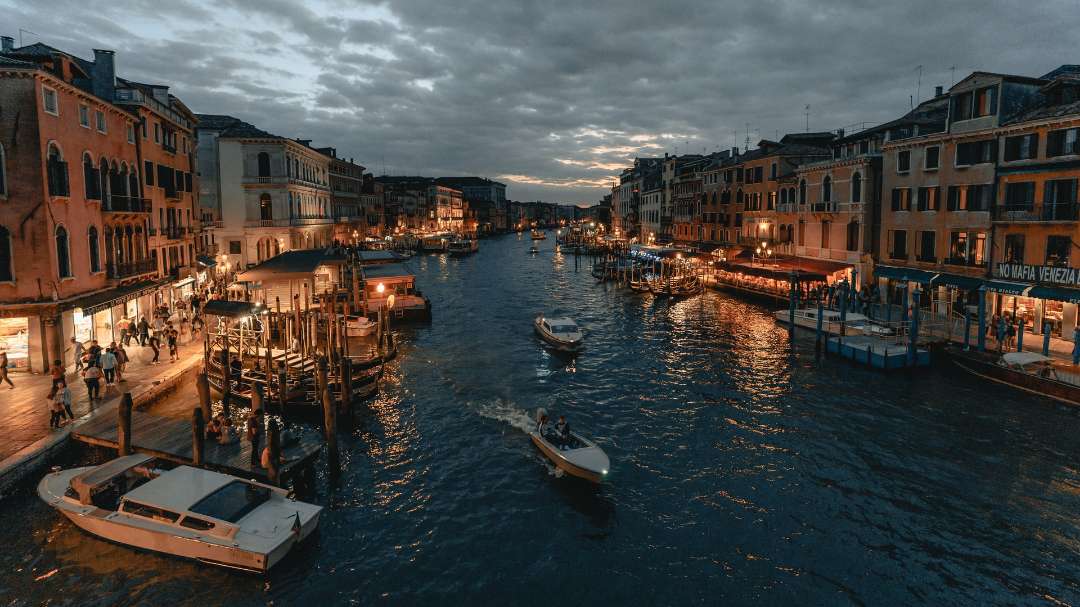 The view of an Italian coastal city lit up at night.