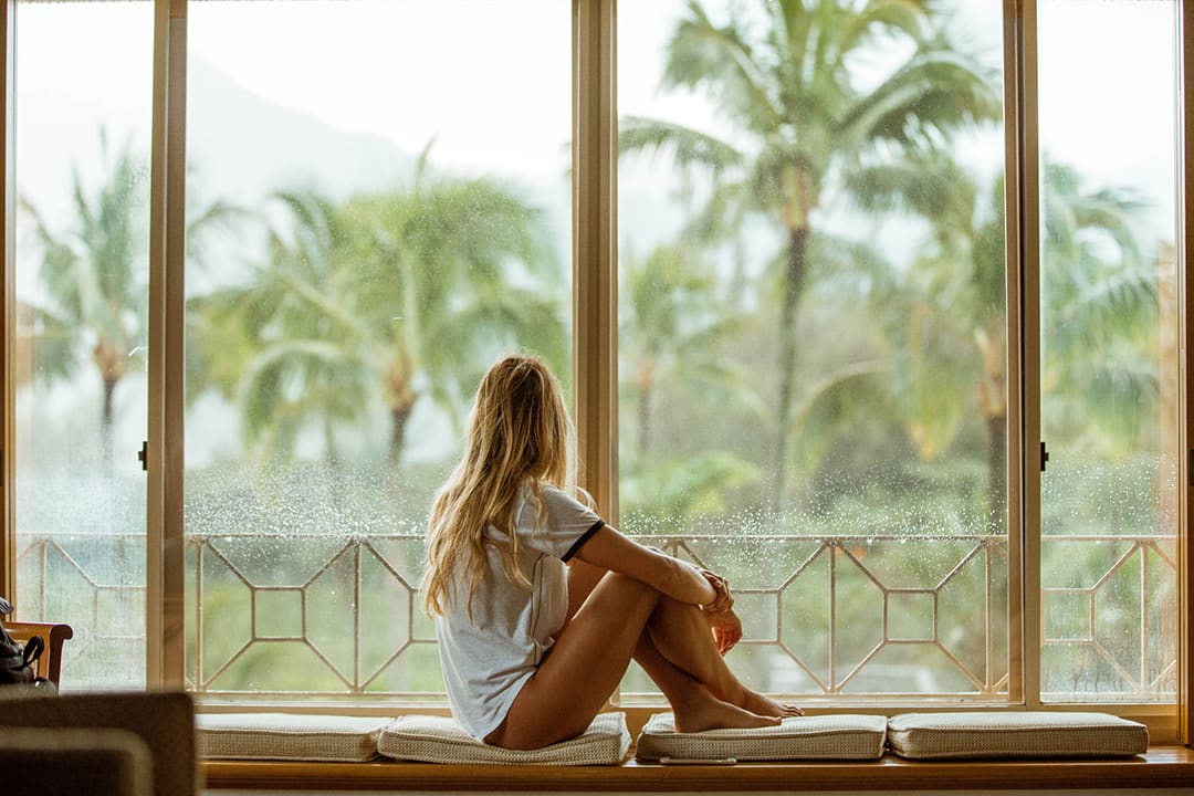 A woman in a white shirt staring out the window