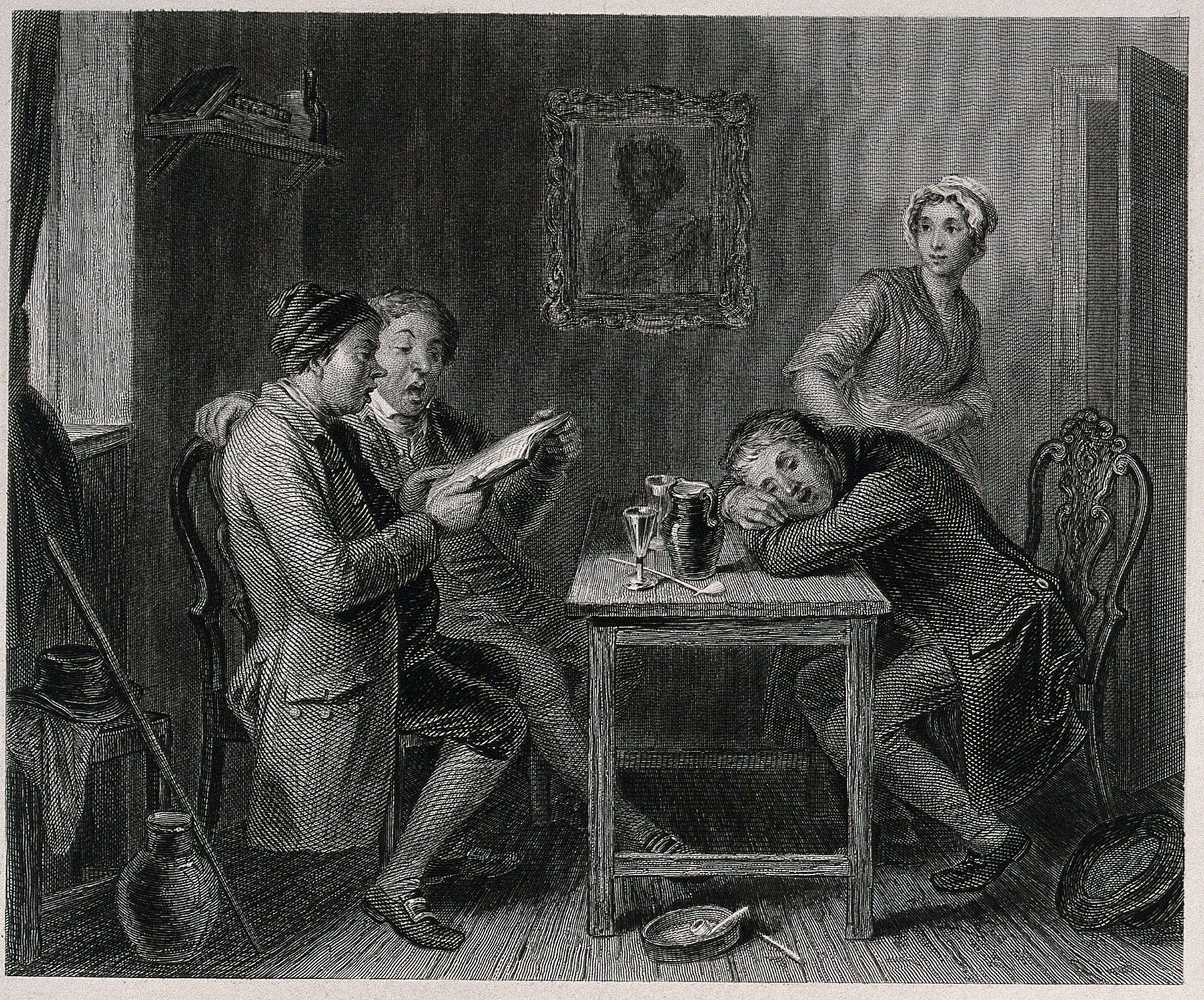 Two men sing from a songbook they are both holding, while a younger man has fallen asleep at the table; a young woman looks on