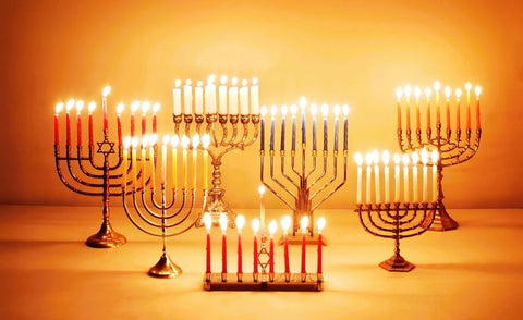 Seven Hanukkiahs of different styles are fully lit on the last day of Hanukkah