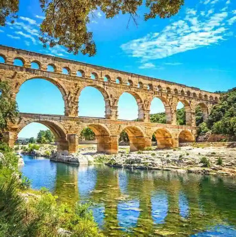 Ancient Roman aqueduct spans a river on a sunny day