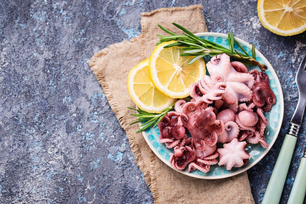 Baby octopus on plate with lemon and rosemary