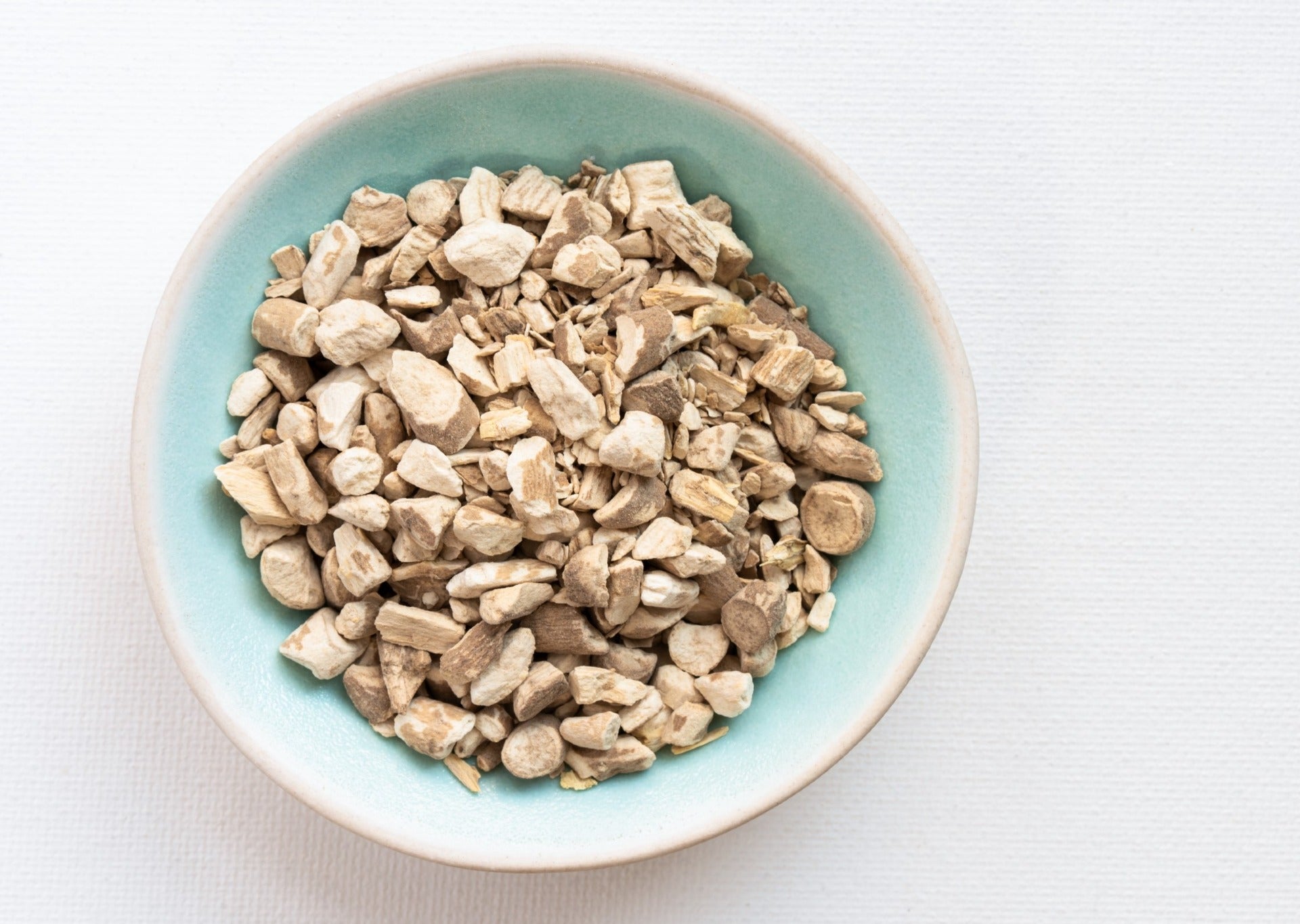 Dried pieces of ashwagandha in a ceramic bowl