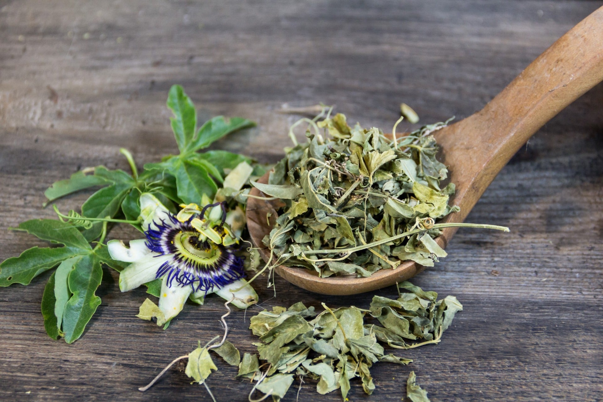 Picture of dried and fresh Passionflower overflowing from a large wooden spoon