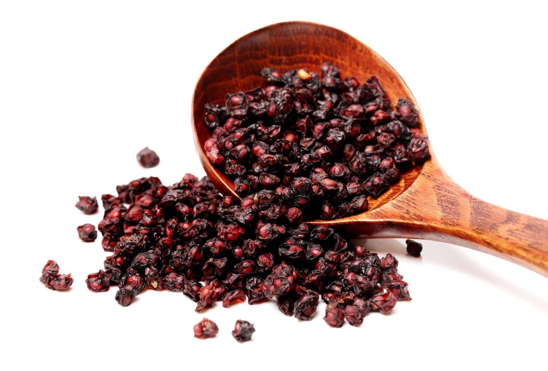 Picture of large wooden spoon overflowing with dried Schisanda berries