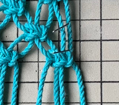 Closeup view of evenly spacing out the knots with the grid and T-pins.