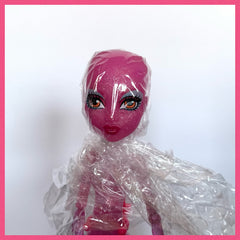 Doll head wrapped in plastic wrap