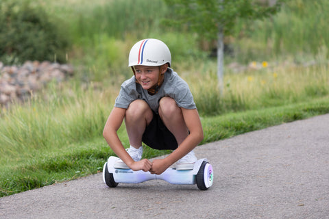 Child riding HOVERBOARD.com Pulse LED Hoverboard 6.3" while crouching