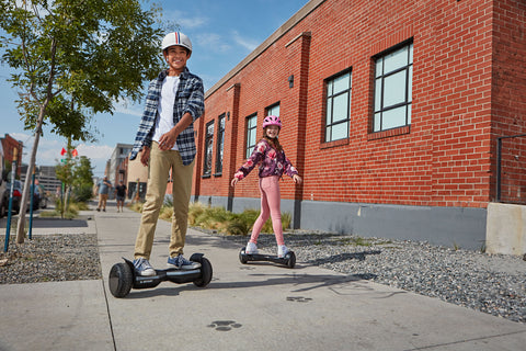A teen and child riding GOTRAX Infinity Pro and Flash LED Hoverboards