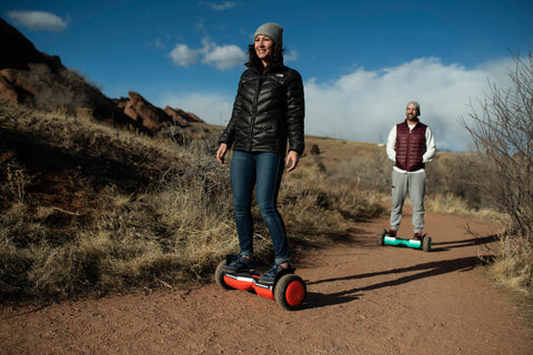 Woman and Man riding GOTRAX Red and Green SRX Pro All Terrain Hoverboards