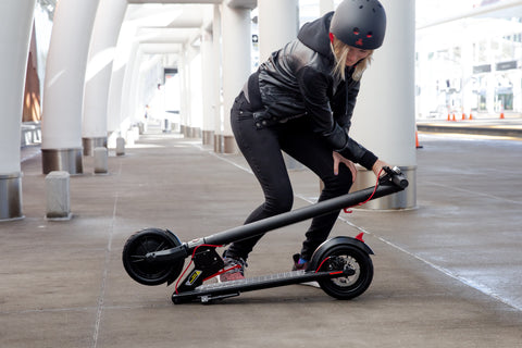 Woman locks GXL V2 Foldable Electric Scooter into the Folded Position