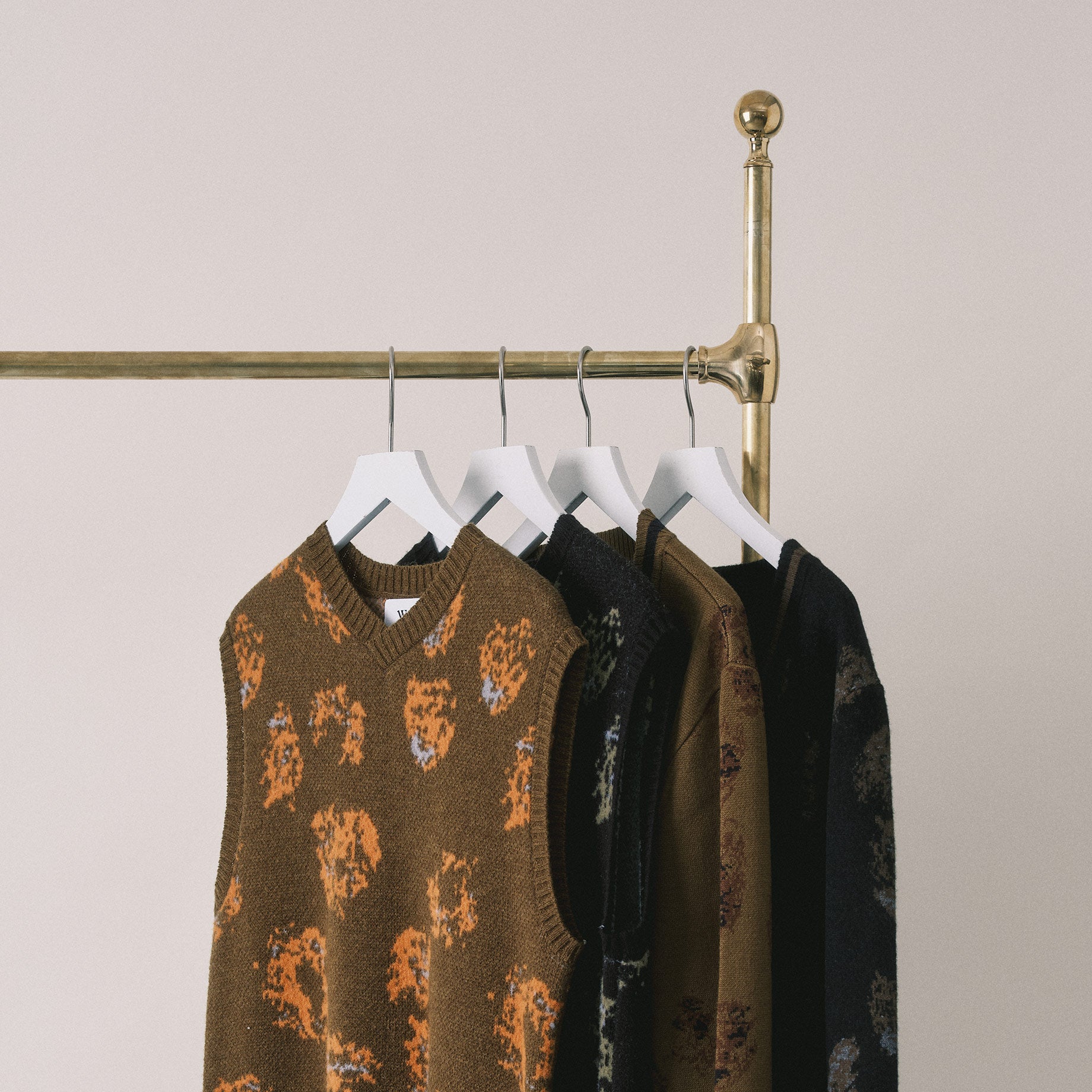 Patterned knitted Wax London clothing hanging on a brass rail