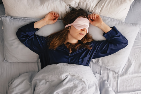 A woman in sleeping and wearing an eye mask