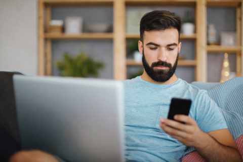 A man using his laptop and phone