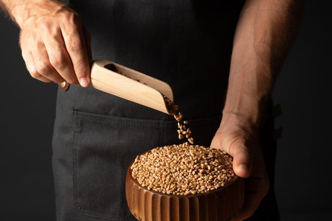 man pouring wheat berries in the bowl
