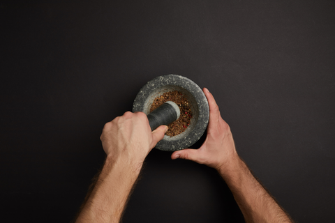 hand grinding ingredients in mortar and pestle