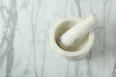 white mortar and pestle on marble countertop