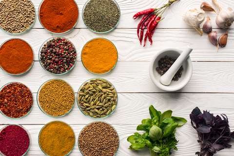 mortar and pestle with tons of spices in bowls