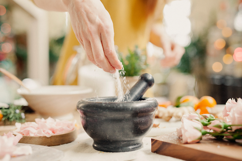 woman putting salt into mortar and pestle