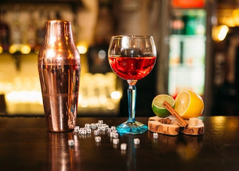 cocktail shaker with cocktail in glass