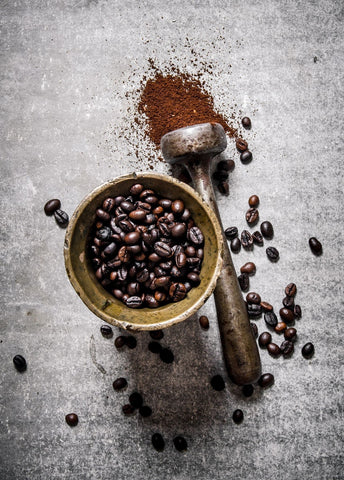 coffee beans in brass mortar and pestle