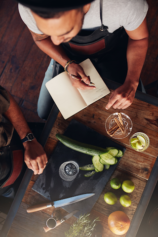 A person taking notes to learn how to be a mixologist