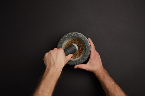 hands using mortar and pestle 