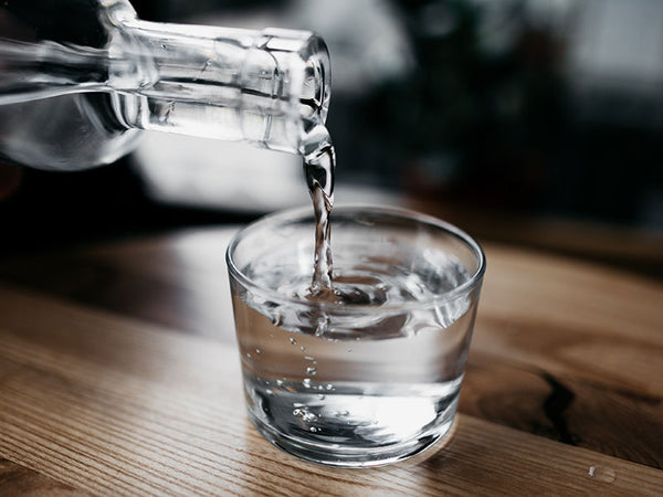 glass bottle pouring water into a glass