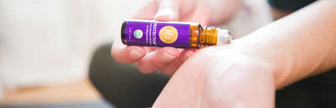 applying protector essential oil roll-on to inside of wrists
