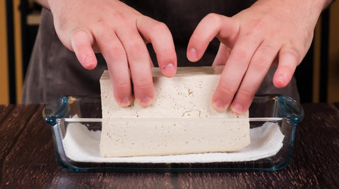 Place the block of tofu onto this layer of absorbent material.