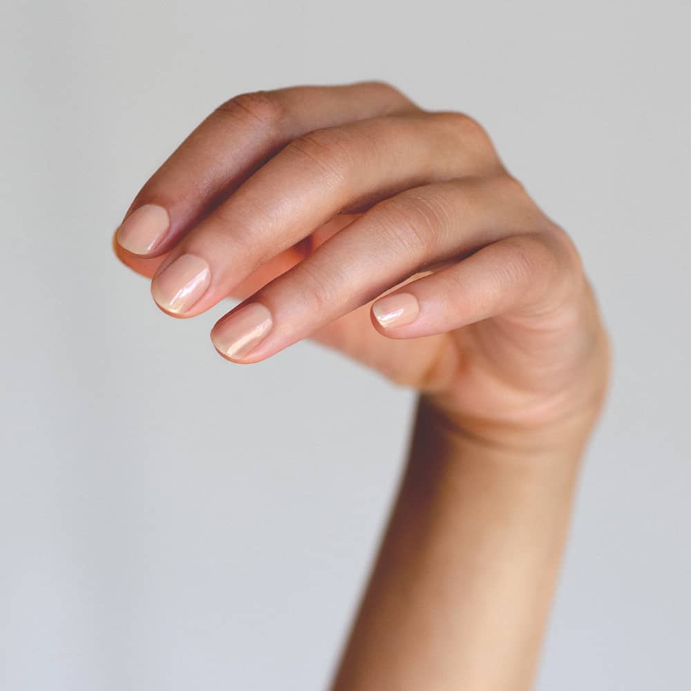 neutral beige sheer nail polish hand swatch on medium skin tone by sienna