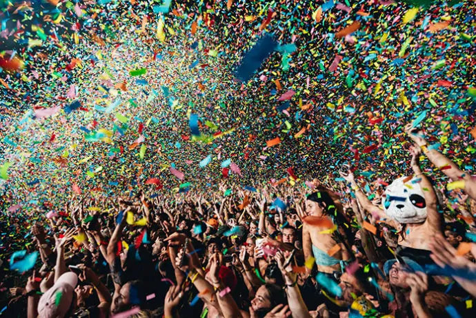 crowd throws confetti in the air in Byron Bay Falls Festival