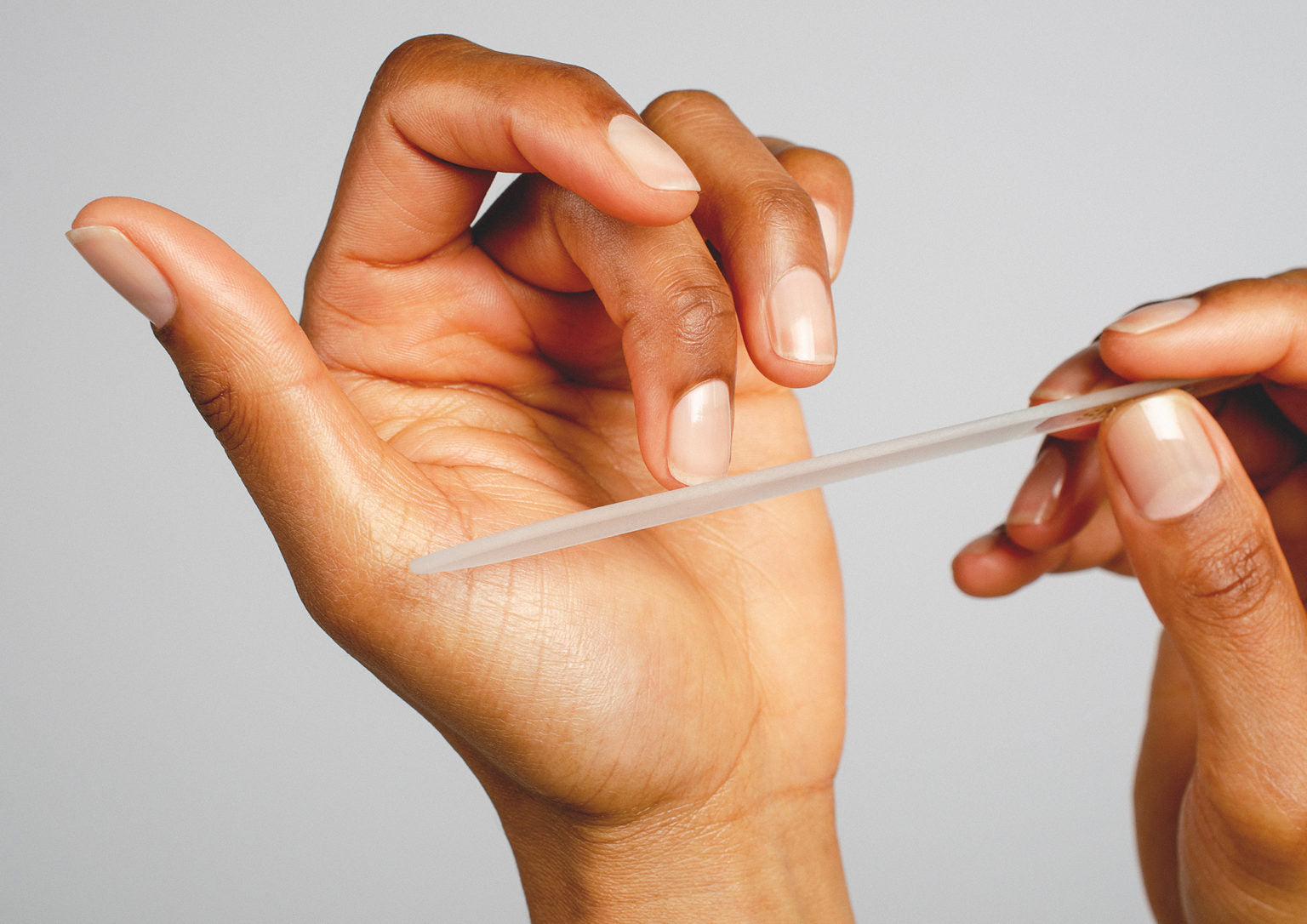 glass nail file on medium skin tone by sienna on white background