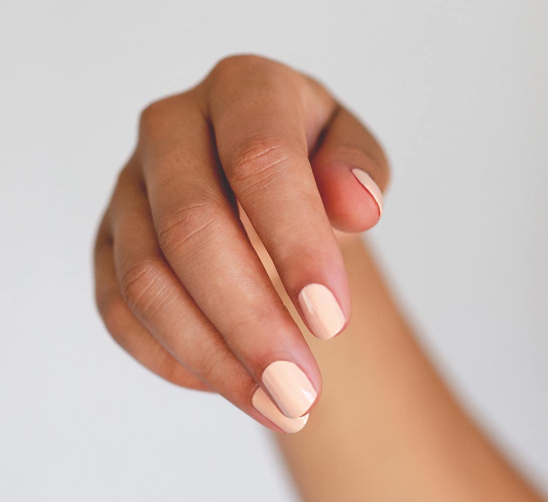 Peach pastel nail polish hand swatch on medium skin tone by sienna