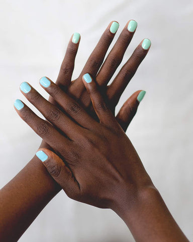 Pastel green and blue nail polish hand swatch on dark skin tone by sienna