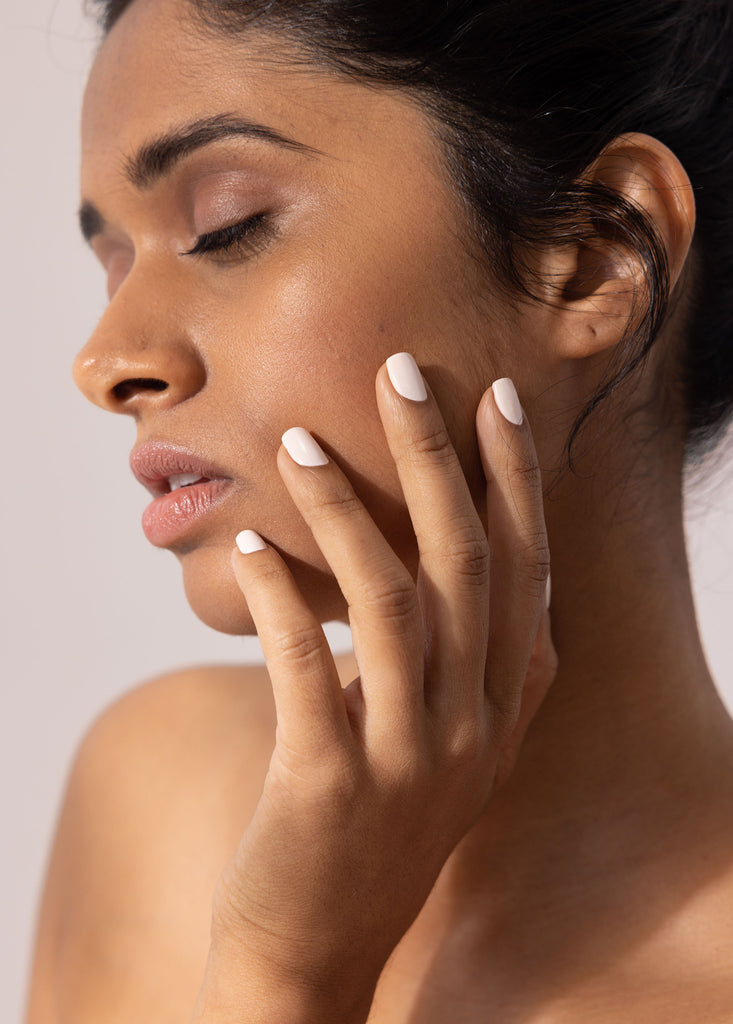 Woman with medium brown skin wearing luna whisper white non toxic nail polish