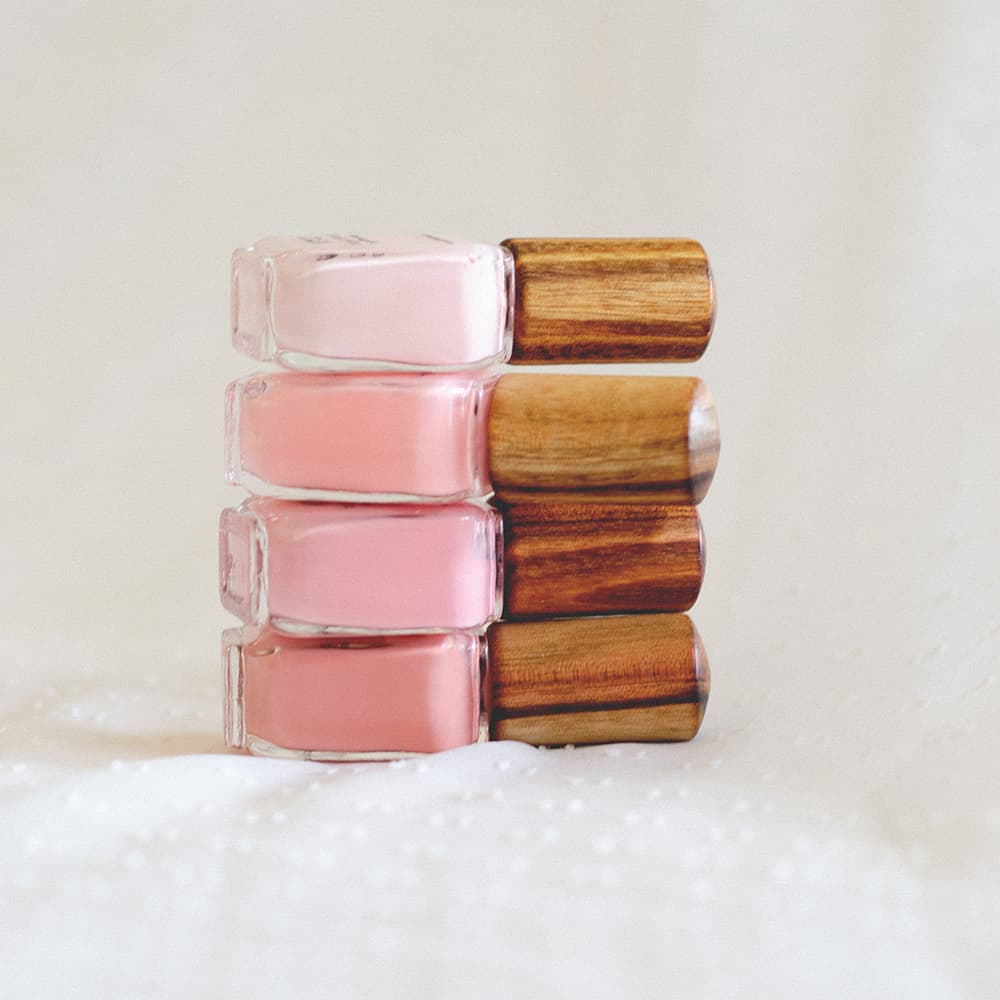 stack of light pink nail polish glass bottle with timber cap by sienna