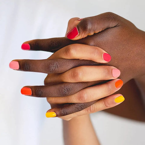 Ombre nail art with orange yellow pink and red nail polish on dark and medium skin tone by sienna