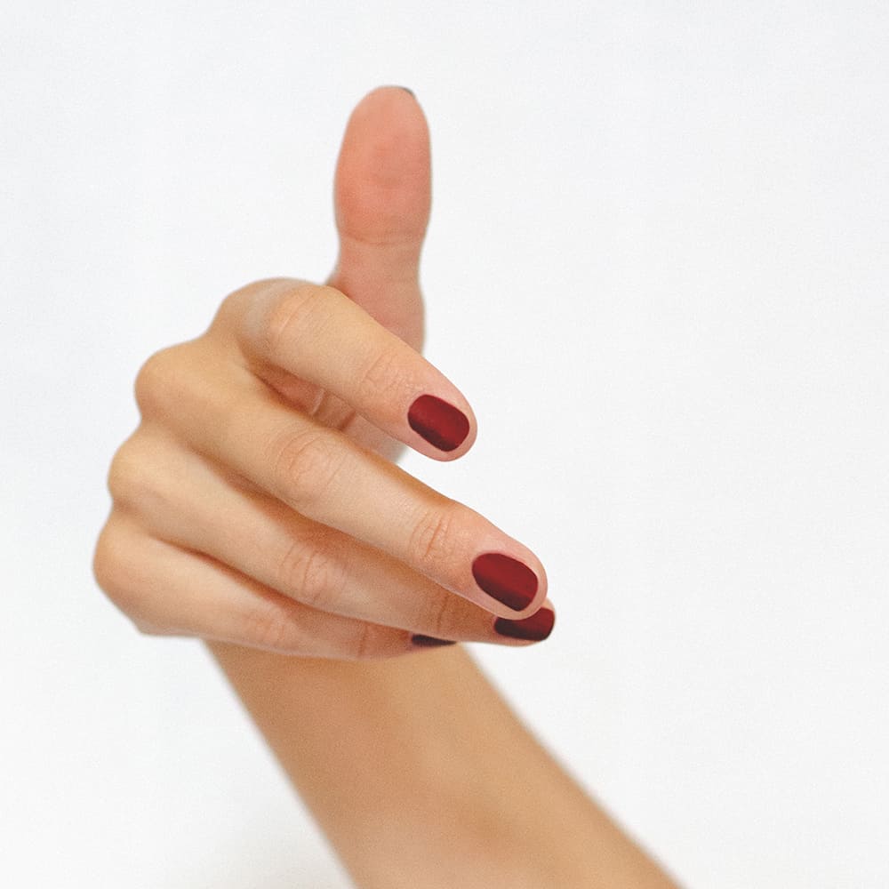 Organic mid-tone red nail polish hand swatch on fair skin tone by Sienna