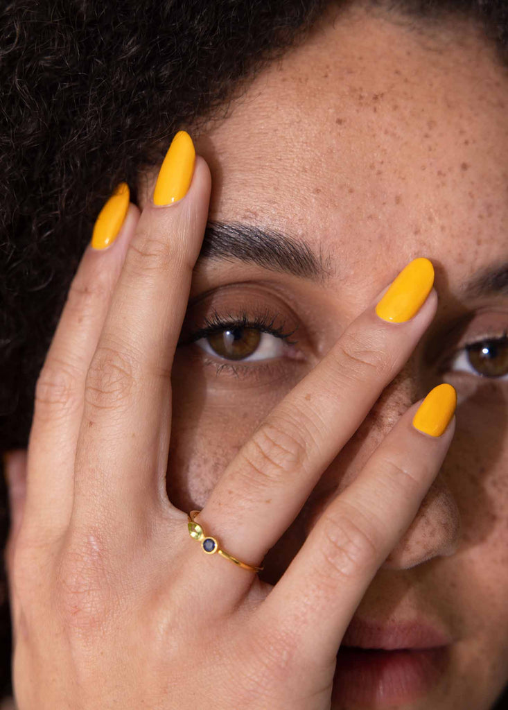 Woman with fair skin wearing Sunflower nail polish by SIenna with freckles and brown eyes.