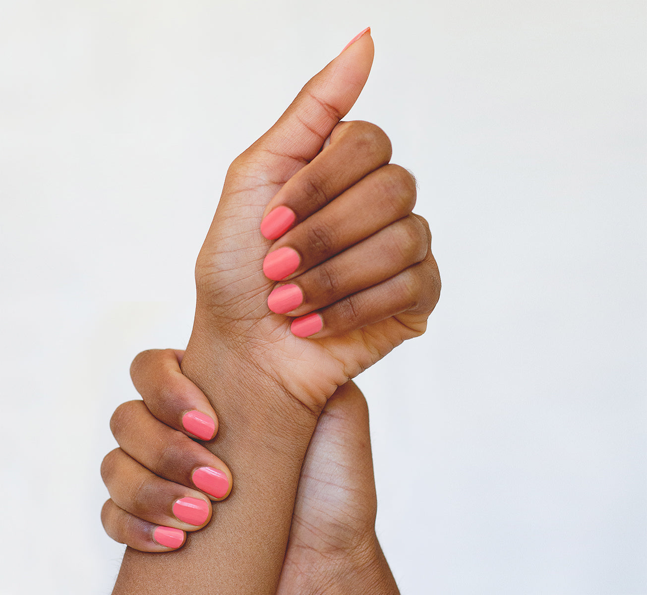 Peachy pink nail polish hand swatch on medium skin tone by sienna