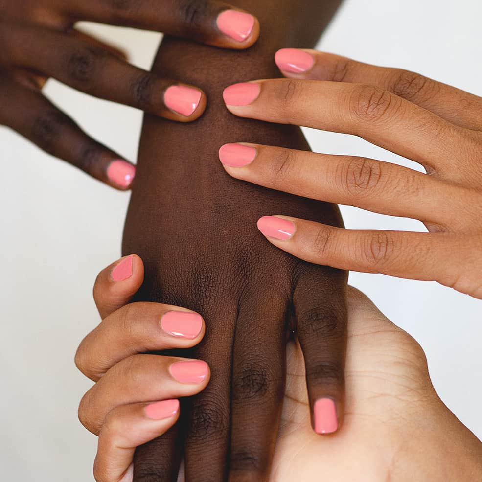 Pink peach nail polish hand swatch on medium and dark skin tone by sienna