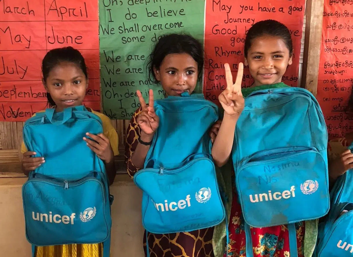 young girls at school holding unicef backpacks