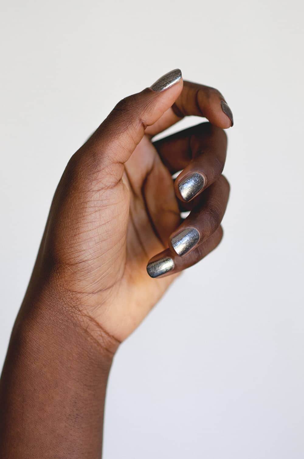 Crushed hematite crystal nail polish hand swatch on dark skin tone by sienna