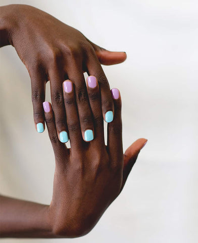 Pastel purple and blue nail polish hand swatch on dark skin tone by sienna